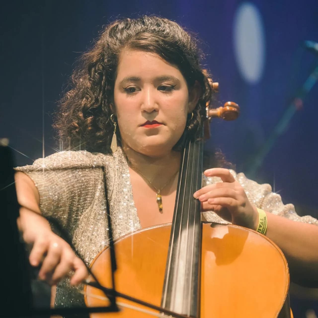 Stephanie Alves ao violoncelo, sob luz de palco